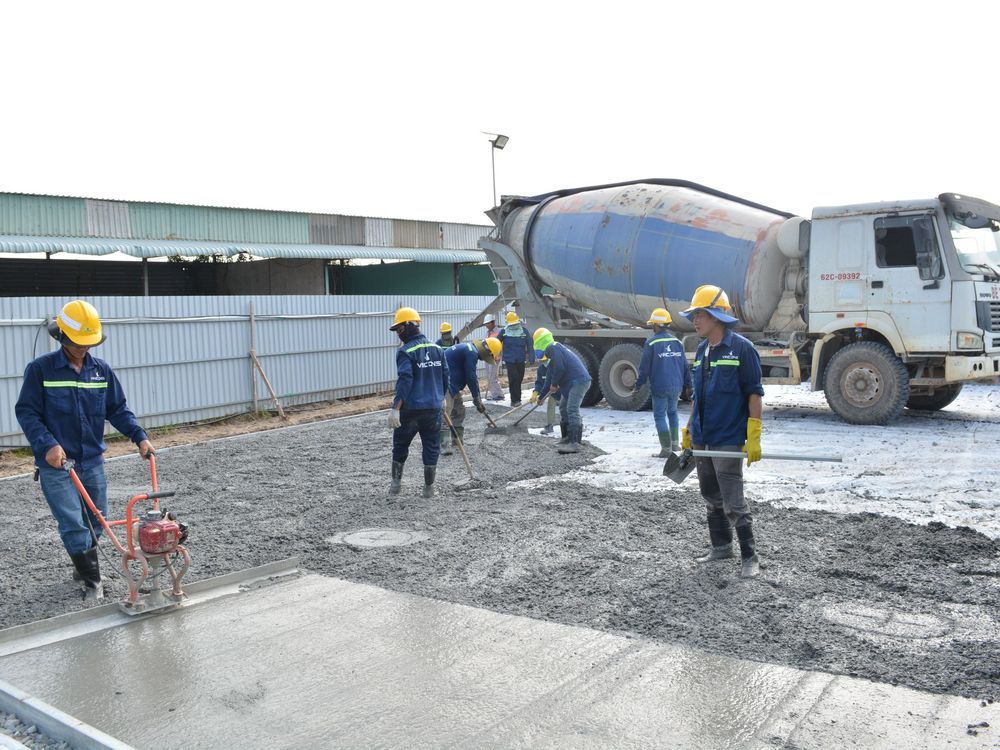 Crew pouring and finishing a concrete slab